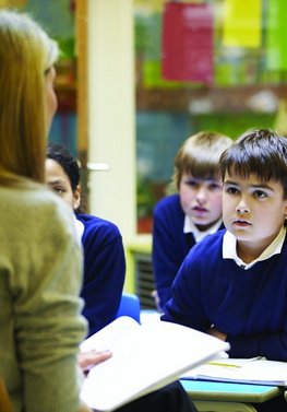 Schüler hören einer Lehrerin aufmerksam zu.