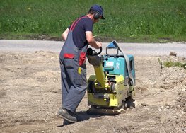 Hier ist die Arbeit mit einer Rüttelplatte zu sehen.