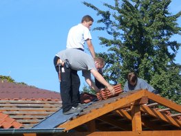 Das Bild zeigt Schüler bei der Verlegung von Dachziegeln im Bereich einer Kehle.