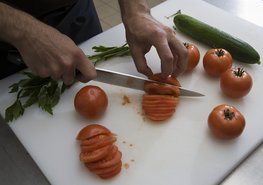 Hier werden mit dem Messer Tomaten geschnitten