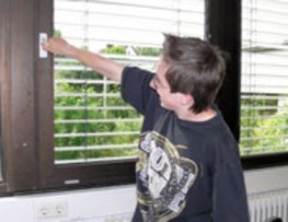 Dieses Bild zeigt einen Schüler, der versucht ein Fenster zu öffnen.