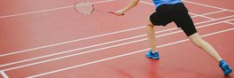 Eine Frau spielt Badminton auf einem Badmintonfeld.