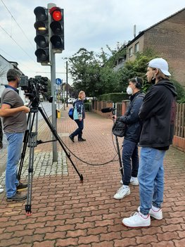 Ein Kamerateam filmt das korrekte Überqueren der Straße.