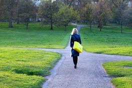 Junge Frau, die einen Weg im Park weg läuft