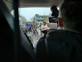 Ein Kameramann filmt aus dem Auto heraus die Übungsfahrradfahrt einer Lerngruppe auf der Straße.