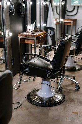 Ein Friseursalon, der mit Friseurstühlen und Friseurspiegeln ausgestattet ist.