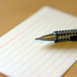 Ein Kugelschreiber liegt auf einer leeren Karteikarte