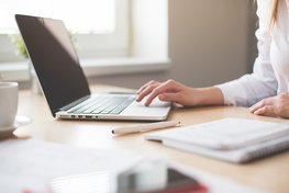 Eine Frau schreibt am Laptop eine Nachricht.